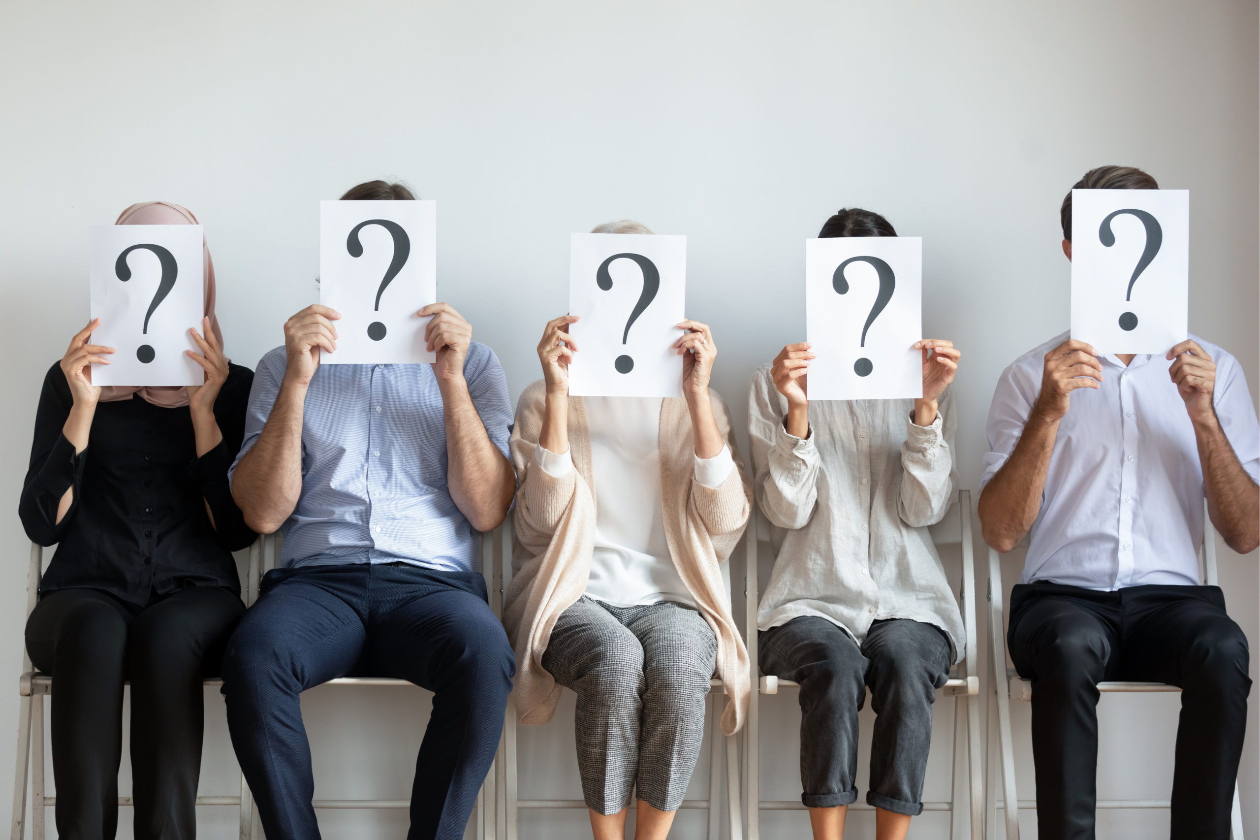 Three people holding question mark signs - Qualitative Recruitment